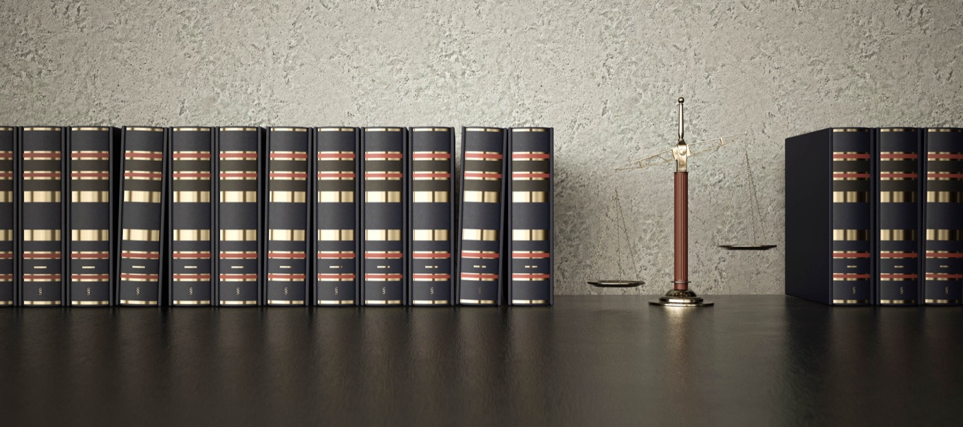 Bibliothèque de codes juridiques et balance de la justice sur un bureau